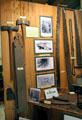 Display of photos, tools & equipment used in harvesting of trees, manufacturing of logs & transport to market at El Dorado County Historical Museum. Placerville, CA.