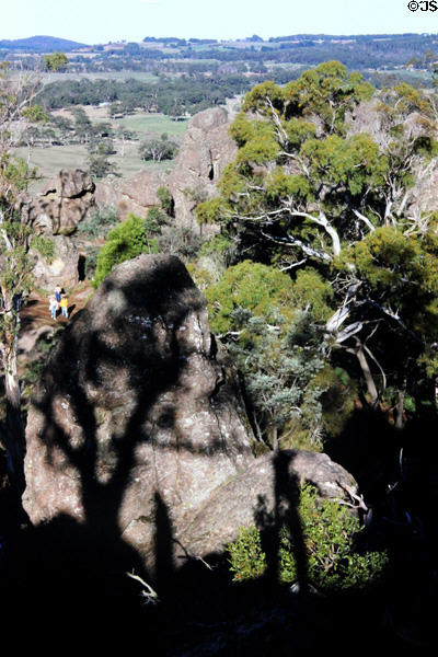 Hikers making their way though rocks & trees of Hanging Rock, scene of a well-known film. Australia.