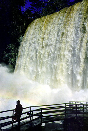 Tourist walks the bridges along the base of Iguaçu Falls. Brazil.