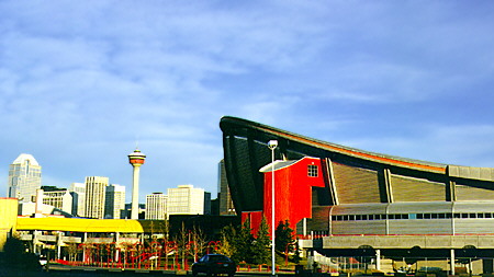 Calgary Saddledome in Stampede Park & skyline with Calgary Tower in distance. Calgary, AB.
