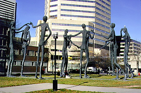 Tall dancing sculpture figures in park at 6th Avenue Southwest & 1st Street Southeast. Calgary, AB.