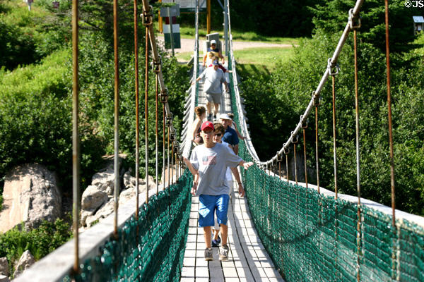 Crossing suspension foot bridge on Fundy Trail Parkway. NB.