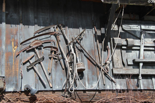 Antique farm tools displayed on side of old barn. Kleinburg, ON.