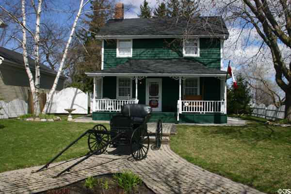 Heritage house with antique carriage on walkway. Kleinburg, ON.