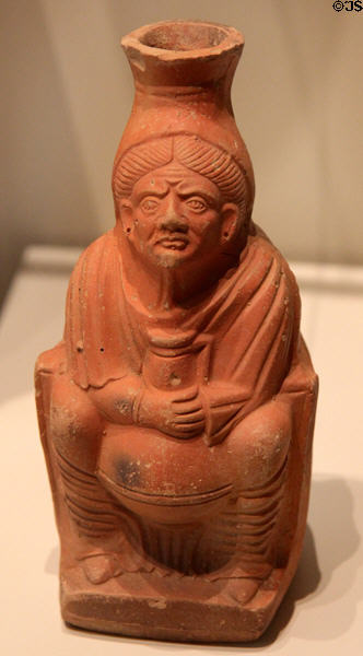 Roman terracotta pot of wine in shape of figure of old woman holding a pot of wine (c200 CE) from North Africa at Royal Ontario Museum. Toronto, ON.