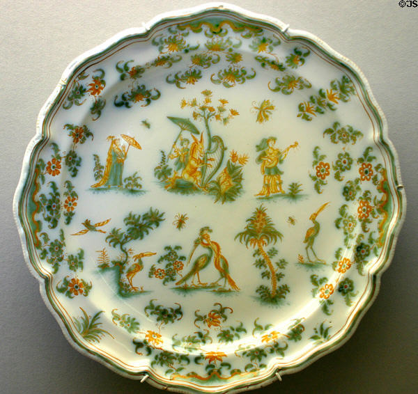 Faience plate painted with grotesque scenes (1745-60) by Manuf. Olerys et Laugier of Moustiers, France at Ariana Museum. Geneva, Switzerland.