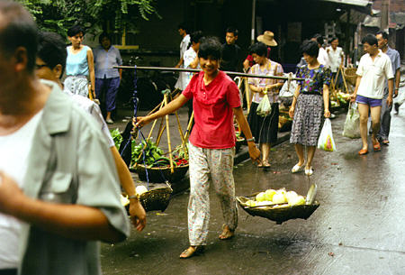 Locals carry a variety of goods along Yichang streets. China.