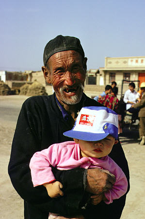 Grandfather holds his grandchild in country village outside of Lanzhou. China.