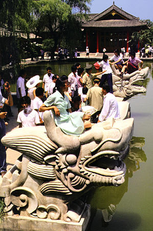 Resting on stone statues at the Hua Quing hot springs. China.