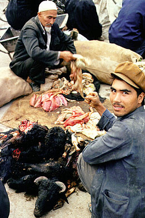 Preparing meat to sell during Kashgar's Sunday market. China.