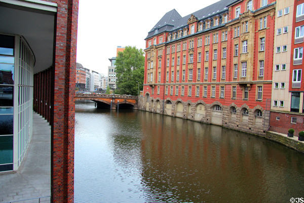 Bridge crossing Alsterfleet waterway lined with buildings. Hamburg, Germany.