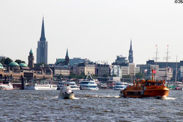 Passenger ferry crossing harbor with towers of Hamburg in background. Hamburg, Germany.