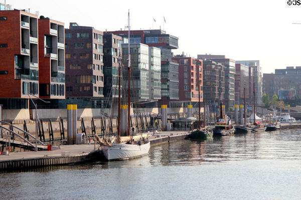 Modern buildings & boats at moorings overlooking Elbe River in HafenCity. Hamburg, Germany.