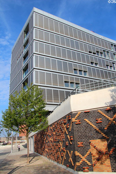 Decorative brickwork of flood barrier in front of modern office building on Dalmannkai in HafenCity. Hamburg, Germany.