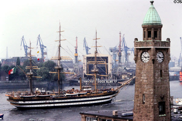 Port Clock Tower at St Pauli Landungsbrücken with Amerigo Vespucci, training tall ship of the Italian navy in the background. Hamburg, Germany.
