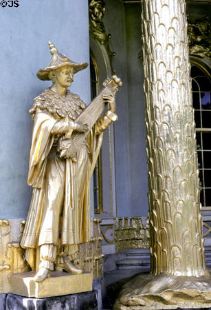 Gold Chinese string musician with wide hat on Chinese Teahouse. Potsdam, Germany.