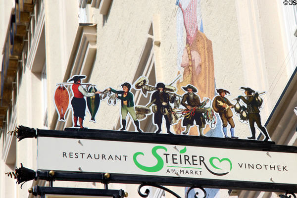 Restaurant sign with figures representing market professions at Viktualienmarkt. Munich, Germany.