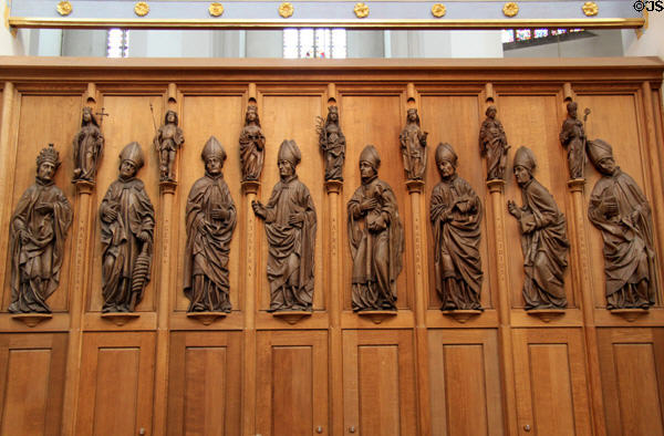 Wall with carved saints over statues of bishops at Frauenkirche. Munich, Germany.