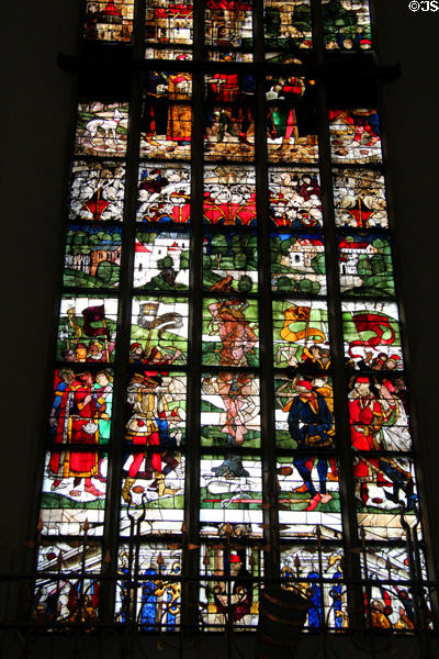 Modern stained glass window features St Sebastian shot with arrows at Frauenkirche. Munich, Germany.