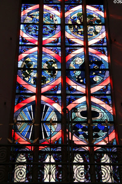 Modern stained glass window features creation story at Frauenkirche. Munich, Germany.