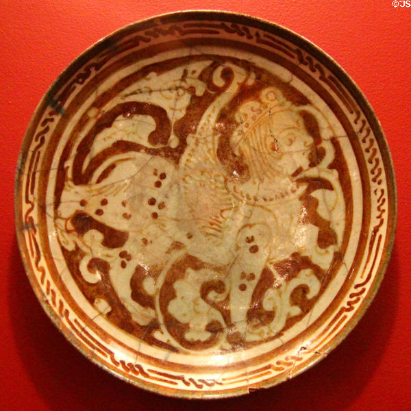 Earthenware bowl with mythic winged sphinx with lion body & human face (12thC) from Iran at Five Continents Museum. Munich, Germany.