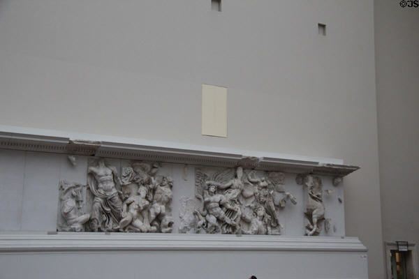Frieze carving originally around exterior perimeter of Pergamon altar now displayed on interior museum walls in front of the ancient structure (c170 BCE) at Pergamon Museum. Berlin, Germany.