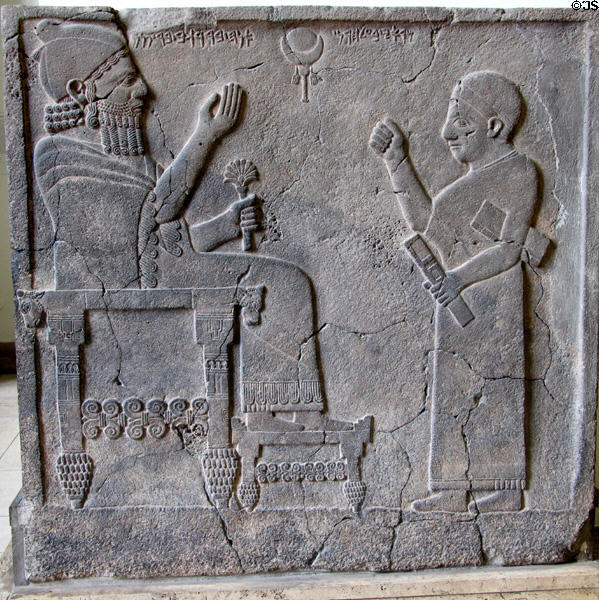 Basalt relief carving of King Barrakib on throne & his scribe with inscription writing in Aramaic from Sam'al (Zincirli) in Turkey at Pergamon Museum. Berlin, Germany.