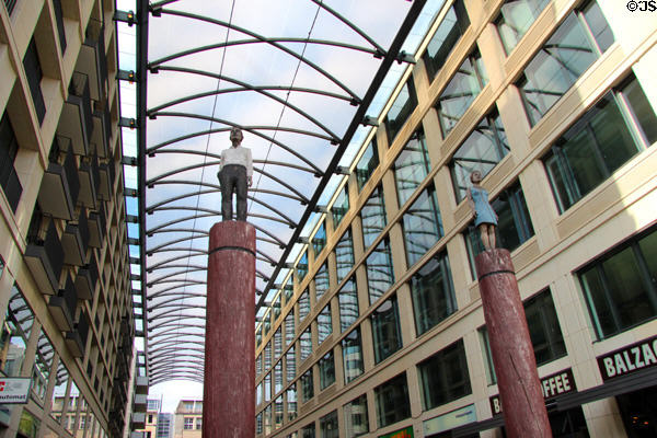 Pair of modern buildings spanned by glass-roofed gallery with statues atop columns (Karl-Liebknecht-Str. 5). Berlin, Germany.