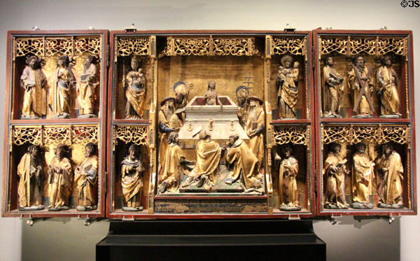 Wooden winged altarpiece centered by Mass of St. Gregory flanked by Virgin Mary & Child, Sts. Anne & Cosmas & Damian with 12 Apostles in wings (c1525) at Aachen Cathedral Treasury. Aachen, Germany.