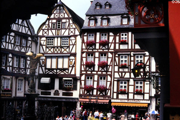 Row of half-timbered buildings in market square with fountain topped by statue of St. Michael wielding his sword (c1950, original destroyed WWII). Bernkastel-Kues, Germany.