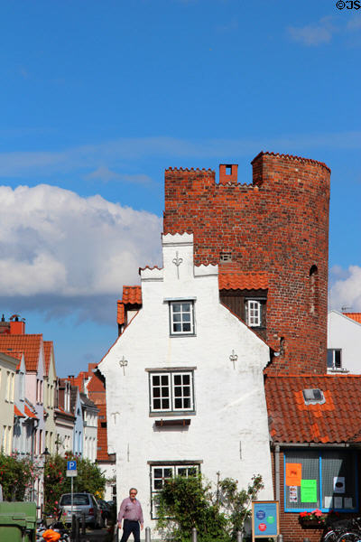 Streetscape with white end of building & semiround tower. Lübeck, Germany.