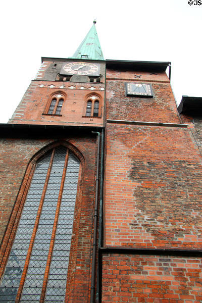 Side view of clock tower with sundial at St Jacob's Church. Lübeck, Germany.