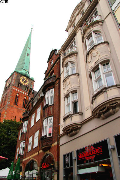 Clock tower of St Jacob's Church above heritage residential buildings. Lübeck, Germany.