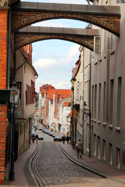 Curving street under arches beside Seaman's Guildhall. Lübeck, Germany.
