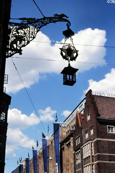 Wrought iron wall lamp embedded to town musician symbols of Bremen. Bremen, Germany.