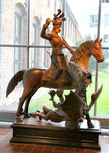 Wood carving of St. Michael slaying dragon at Cultural History Museum. Rostock, Germany.