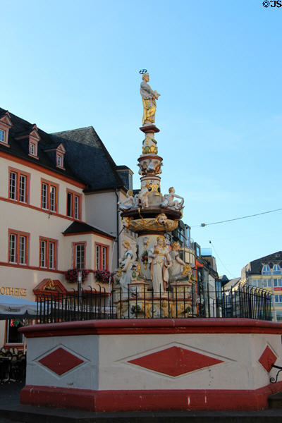 St Peter's Fountain with hexagonal base & buildings in typical Germanic style in Hauptmarkt. Trier, Germany.