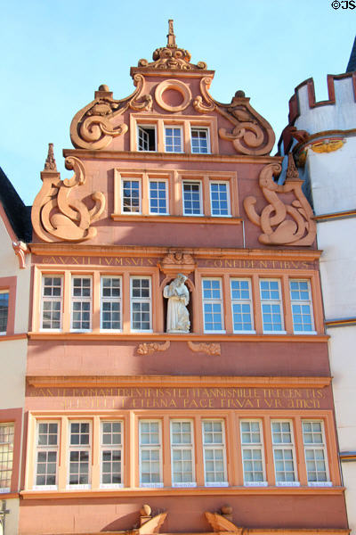 Baroque style building with religious statue in niche on Hauptmarkt. Trier, Germany.
