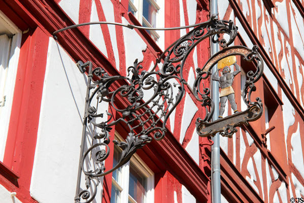 Ornate metal shop sign on outside of Hauptmarkt building. Trier, Germany.