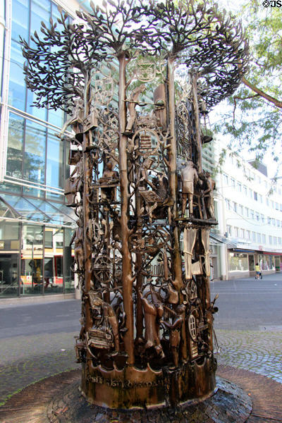 Wrought ironwork Craftsmen's Fountain (1984) depicting nine trees in a circle, with, between the branches, 25 representations of craft workers and occupations by Claus Apel. Trier, Germany.