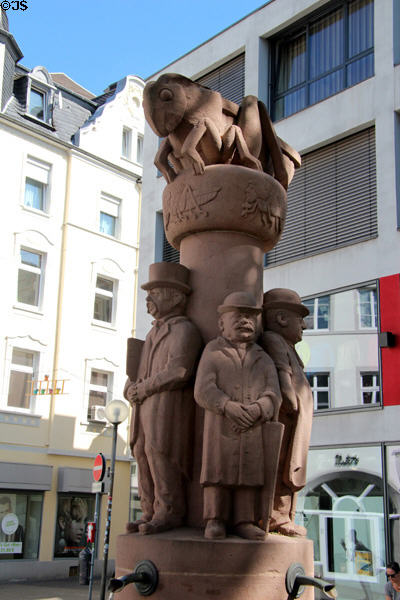 Grasshopper Fountain (1977) pillar with giant grasshopper on top symbolizing Carnival Society of Trier with its first members around the column by Willi Hahn. Trier, Germany.