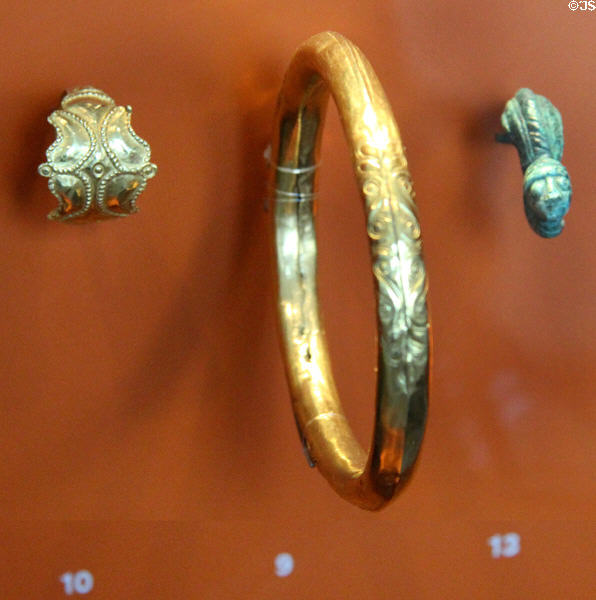 Gold arm & finger rings + bronze decorative pin with face (4thC BCE) at Trier Archaeological Museum. Trier, Germany.