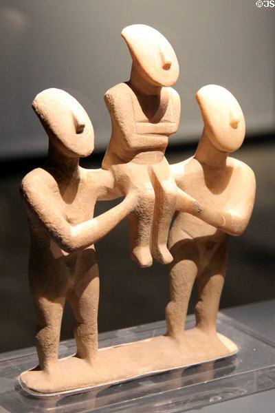 Cycladic marble group carving of two males holding female (2700-2400 BCE) at Bavarian State Archaeological Collection. Munich, Germany.