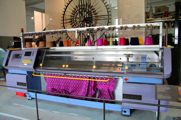 Computer controlled flat knitting machine (1993) produces sweater parts every six minutes which then need to be sewn together at Deutsches Museum. Munich, Germany.