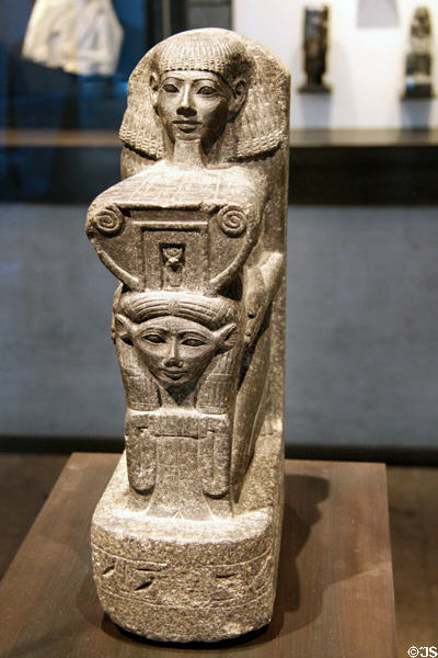 Kneeling figure of architect Senenmut holding symbol of goddess Hathor of granite (18th Dynasty - c1470 BCE) from Armant at Museum Ägyptischer Kunst. Munich, Germany.