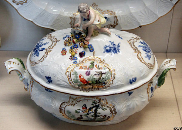 Meissen porcelain terrine with putto angel holding cornucopia lid handle & painted with birds plus blue foliage (c1765-70) at Meissen porcelain museum at Lustheim Palace. Munich, Germany.