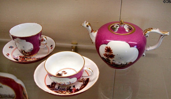 Meissen porcelain purple cups & saucers plus teapot with Asian scenes painted in white quatrefoils at Meissen porcelain museum at Lustheim Palace. Munich, Germany.
