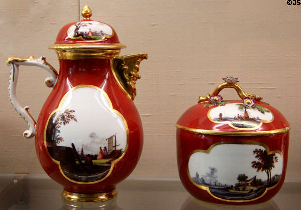 Meissen porcelain red coffee pot & sugar bowl (c1740) with Watteau & trade travel scenes painted in white quatrefoil at Meissen porcelain museum at Lustheim Palace. Munich, Germany.