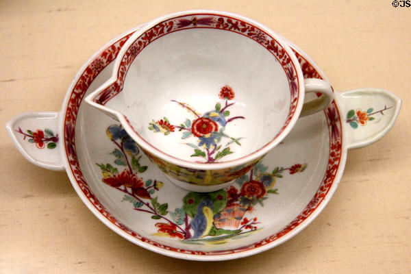 Meissen porcelain spouted bouillon cup on saucer (c1730) painted with Indian flowers used to cool liquid in saucer before drinking from saucer at Meissen porcelain museum at Lustheim Palace. Munich, Germany.