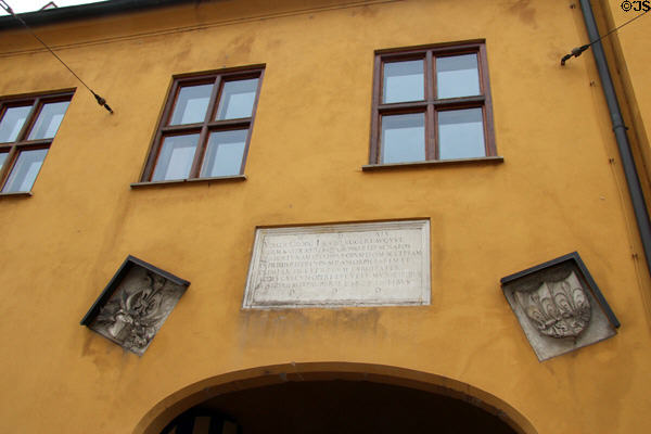 Plaque (1519) & coats-of-arms over entrance at Fuggerei commemorating Jakob Fugger & his deceased brothers. Augsburg, Germany.